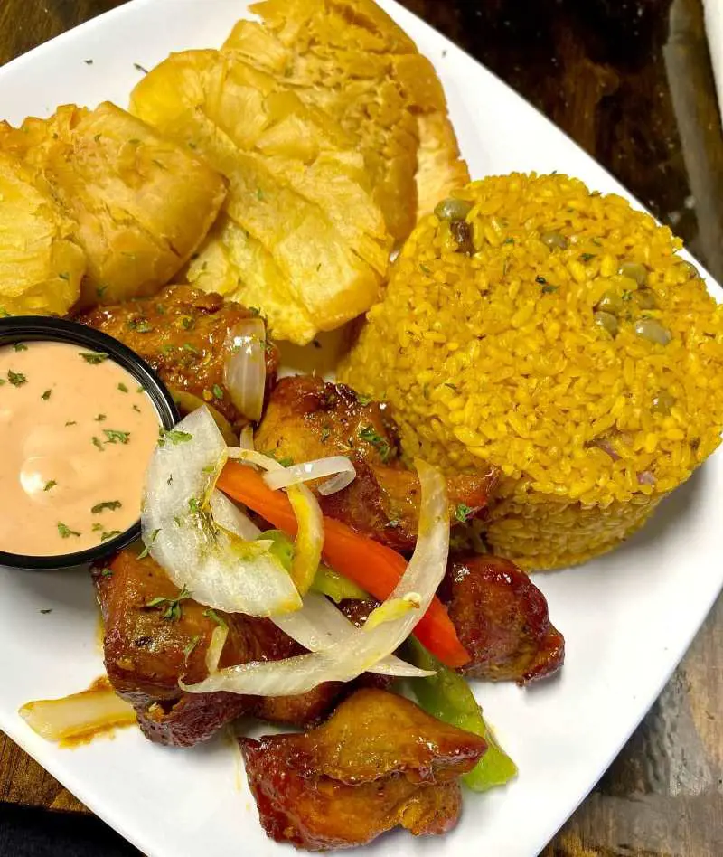 Arroz con gandules served with masas de cerdo frita and tostones de pana