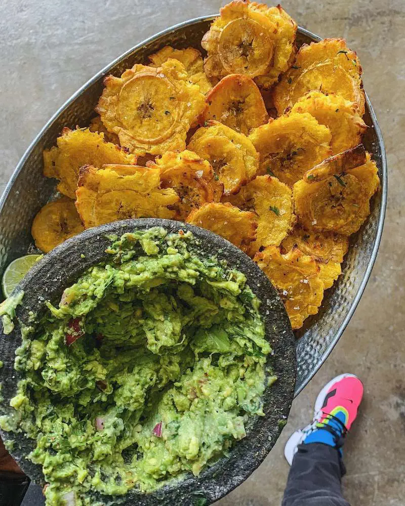 Tostones, twice-fried plantain slices, is commonly found in Latin American cuisine and Caribbean cuisine